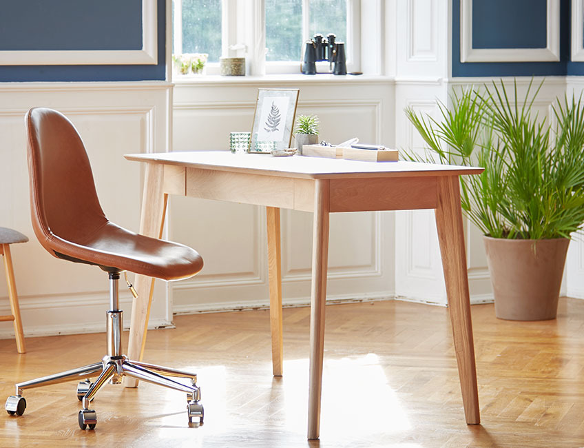 Skrivebord i eg og kontorstol i læder i et stilfuldt rum