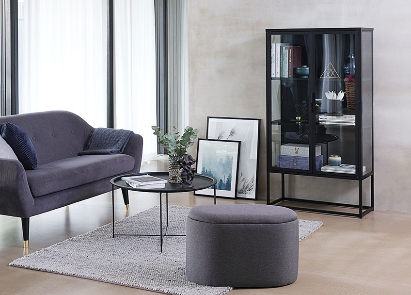 Oval puf i en stue med sofa, sofabord og et vitrineskab