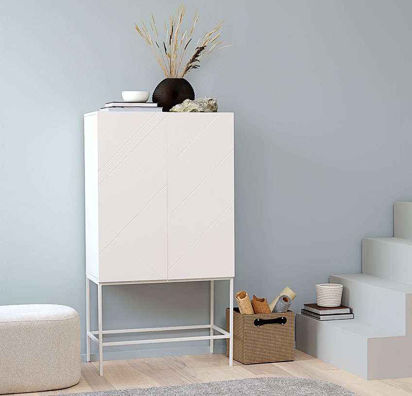 LADBY skab med OREBO puf i off-white og FREJ jute kurv Hvidt skab med sort vase og anden pynt, en hvid puf og en kurv i jute