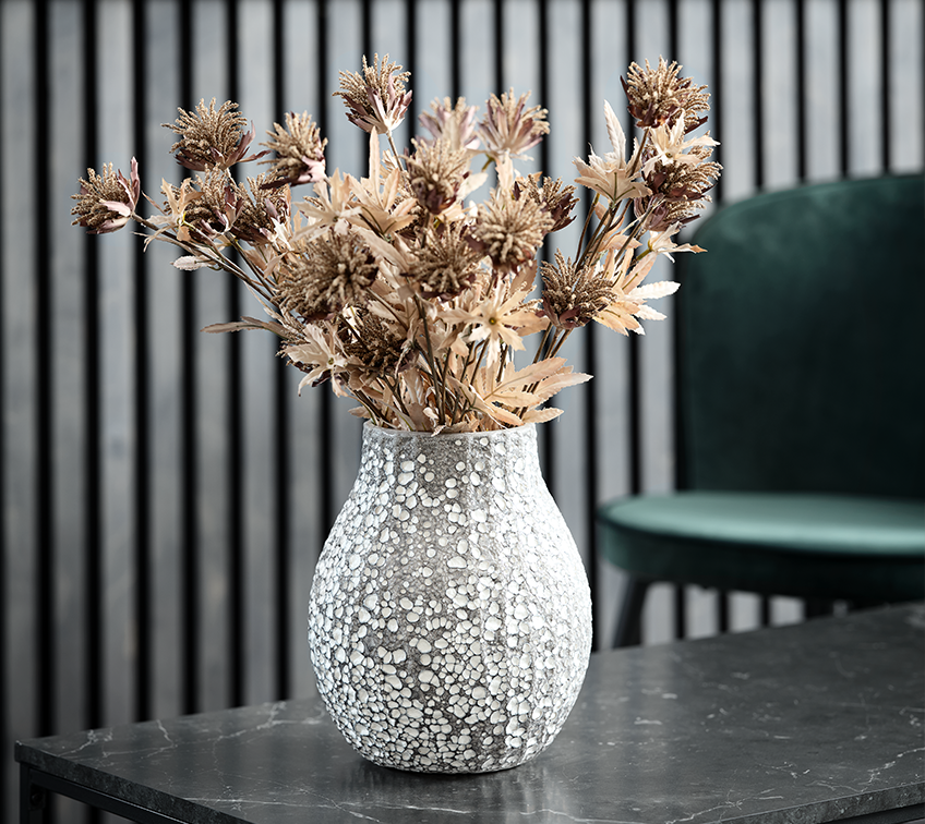 Vase med kunstige blomster, der pynter i en stue
