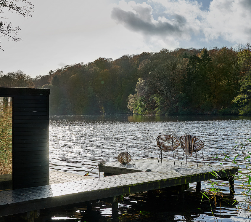 Badehåndklæde, der hænger en loungestol på badebroen ved en sø