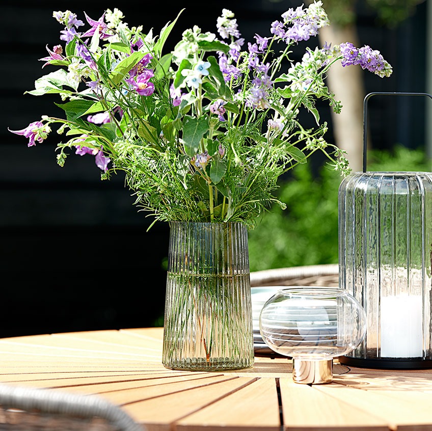 Glasvase på et rundt havebord