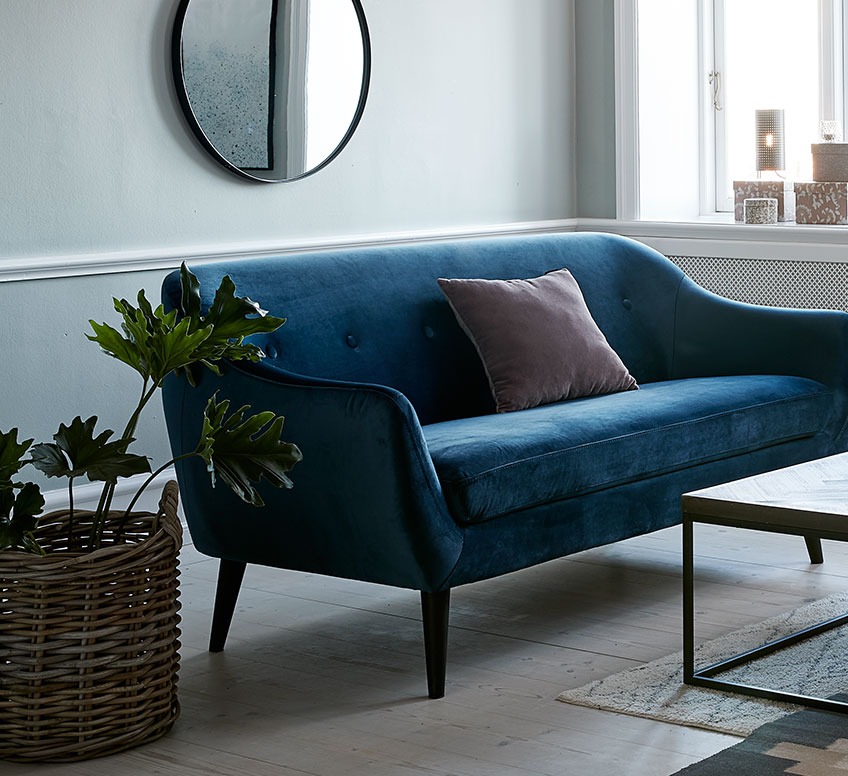 Blå sofa i minimalistisk stue