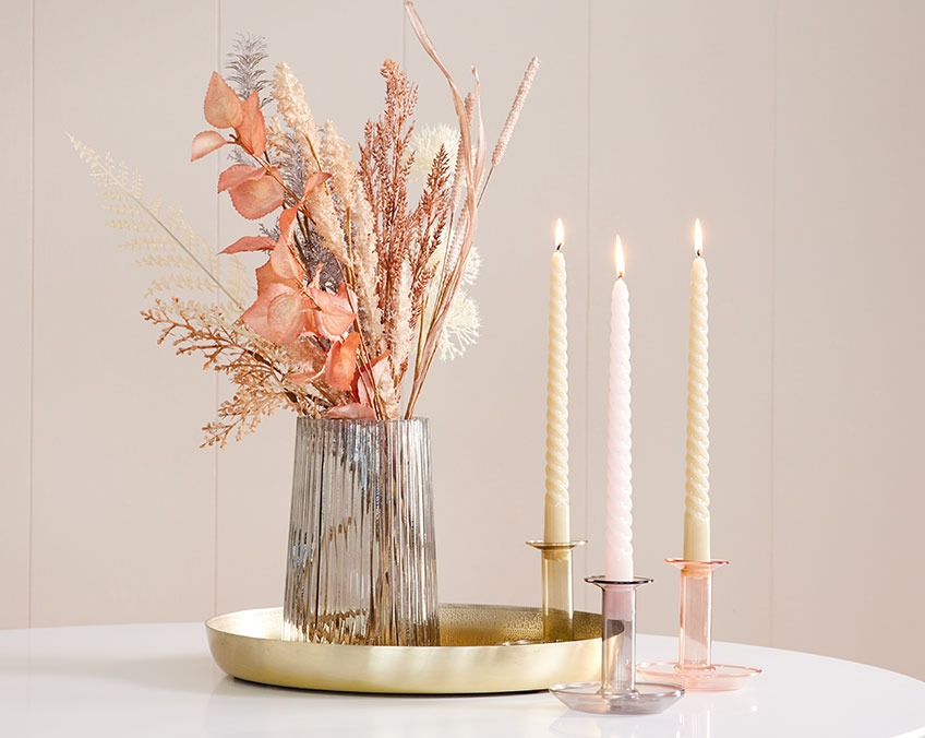 Lysestager med stearinlys og bakke med vase med kunstige blomster