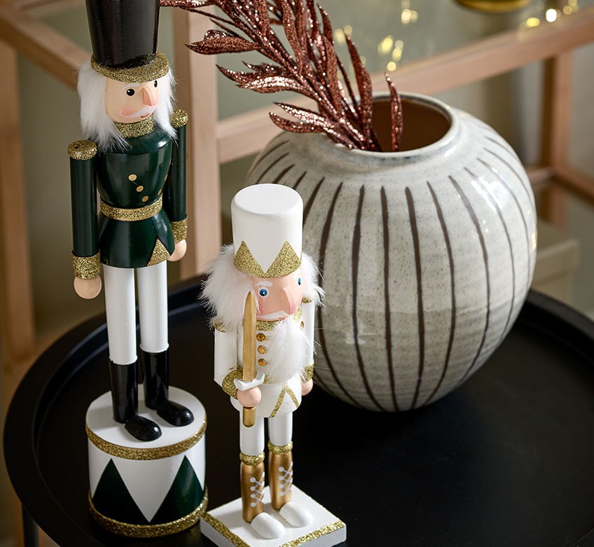 To julefigurer og en vase på et sort hjørnebord