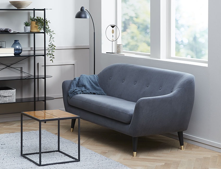 Grå sofa i velour og sofabord i skandinavisk design 