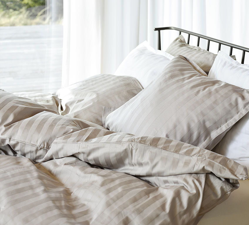 Bed with duvets and pillows with a striped bedding