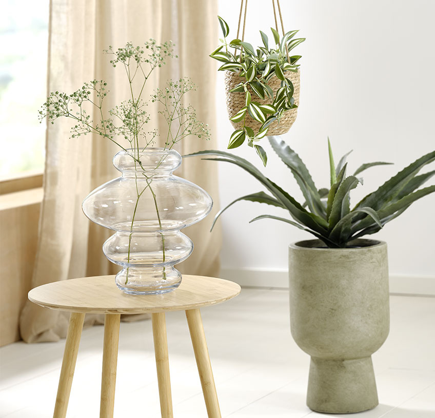 Glasvase på endebord, hængende urtepotte og grøn urtepotte med kunstige planter