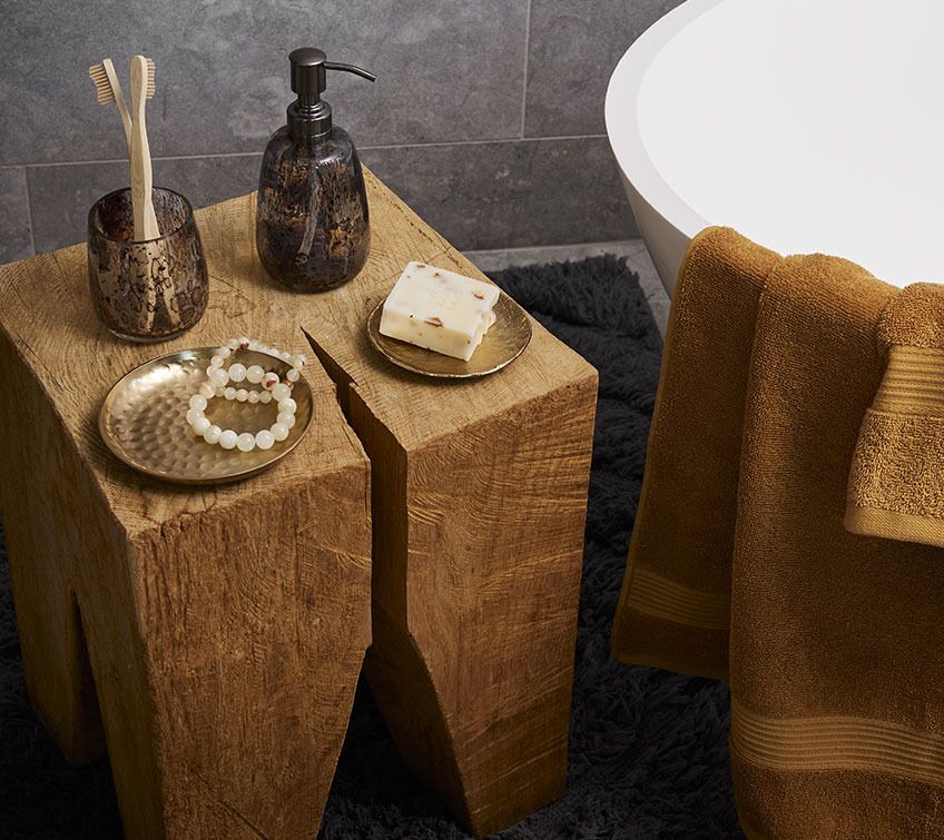 Stor træblok med bakker, tandkrus og sæbepumpe i et badeværelse