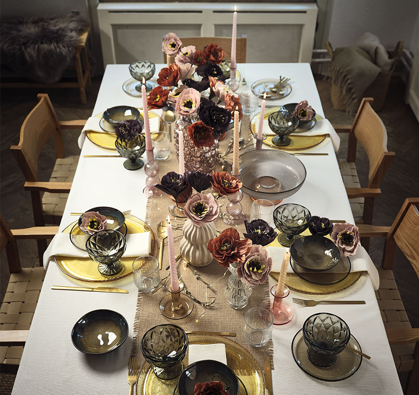 KLAES skåle, ELMER glastallerkener, TONY skåle på fod, LASSE skål, BALDUR stearinlys og THORE vase med PER kunstige blomster Bord dækket med tallerkener, glas, skåle og stearinlys