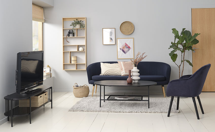 Stue med sort TV-bord, sofa, sofabord og lænestol