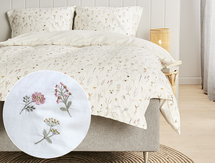 Blomstret sengetøj i et lyst soveværelse