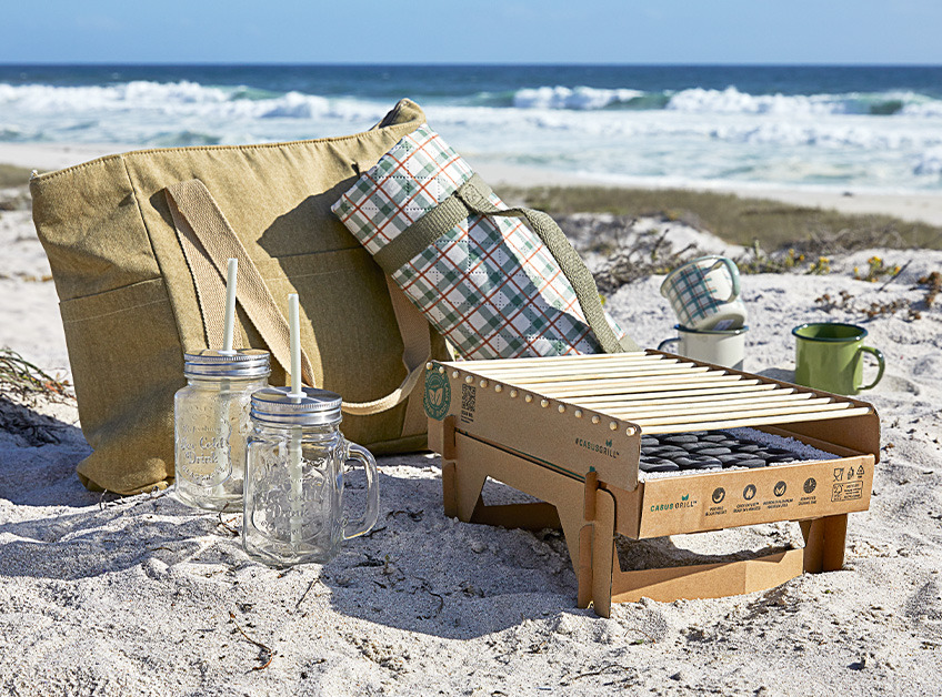 Engangsgrill på strand med en masse strandtilbehør