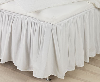 Hvidt kappelagen, der dækker ben eller meder på seng