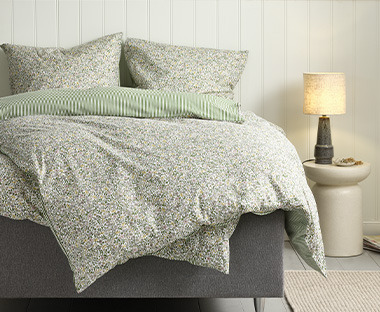 Blomstret sengetøj med stribet bagside i soveværelse