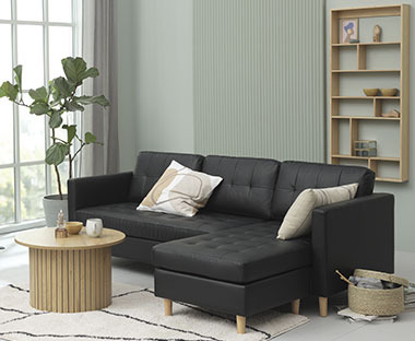 Sofa i kunstlæder, rundt sofabord og bambus væghylde