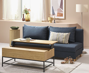 Blå sovesofa i stue med sofabord med opbevaring